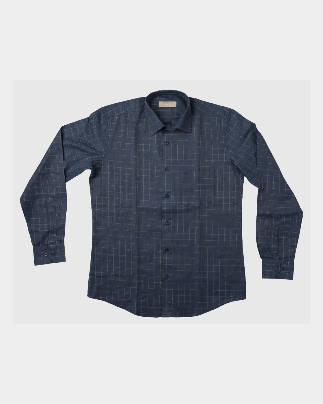 The checked shirt as the brand sent it: laid flat on a plain ground, nobody wearing it.