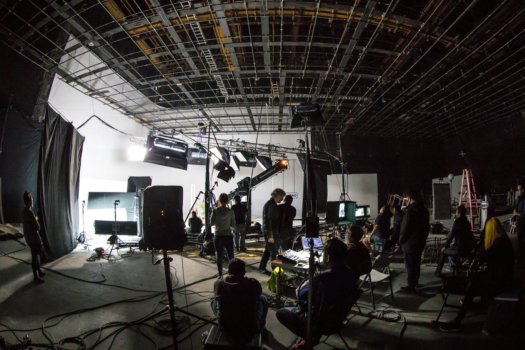 A film crew on a soundstage with lighting and cameras